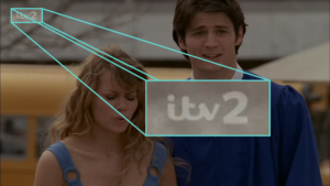 A screenshot of ITV2, showing their old 2015 DOG, with the large 2 in the ITV Reem font. The show is One Tree Hill, and two characters are coincidentally showing pained faces